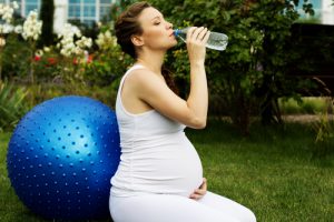 Mujer embarazada bebiendo agua